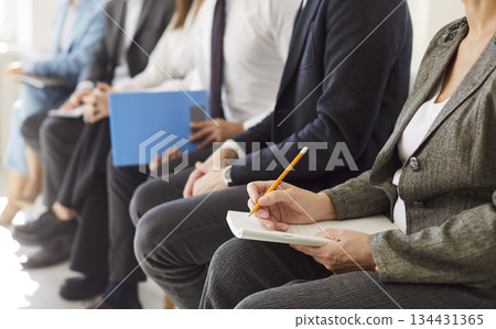 Business professionals seating in conference room, listening to coach, participating in training. Business professionals seating in conference room, listening to coach, participating in training. 134431365