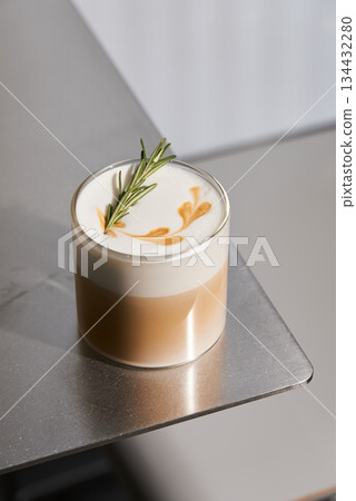 Chic Layered Coffee With Delicate Foam Art And Natural Rosemary Garnish For Trendy Visuals Chic Layered Coffee With Delicate Foam Art And Natural Rosemary Garnish For Trendy Visuals 134432280