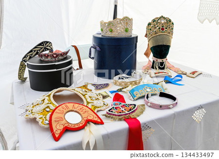 Traditional Russian folk jewelry with kokoshniks bead ribbons and crowns displayed at a cultural historical exhibition table Traditional Russian folk jewelry with kokoshniks bead ribbons and crowns displayed at a cultural historical exhibition table 134433497