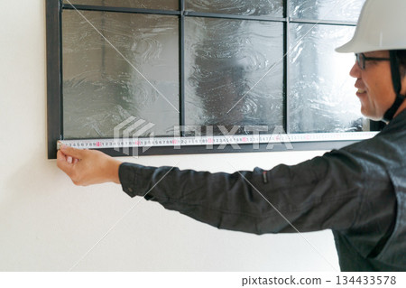 A man doing window maintenance 134433578