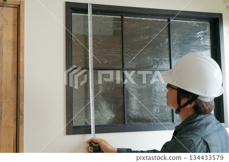 A man doing window maintenance 134433579