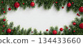 Green pine branches with red ornaments creating a festive border for winter celebrations 134433660