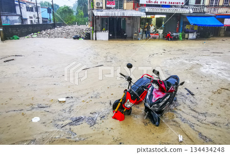 Extreme rainfalls monsoon scooters drown on flooded street Phuket Thailand. Extreme rainfalls monsoon scooters drown on flooded street Phuket Thailand. 134434248
