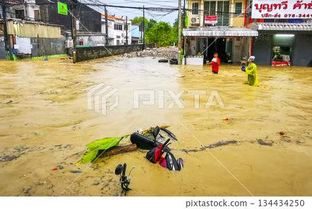 Extreme rainfalls monsoon scooters drown on flooded street Phuket Thailand. 134434250