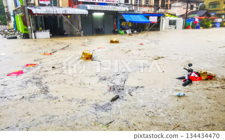 Extreme rainfalls monsoon scooters drown on flooded street Phuket Thailand. 134434470