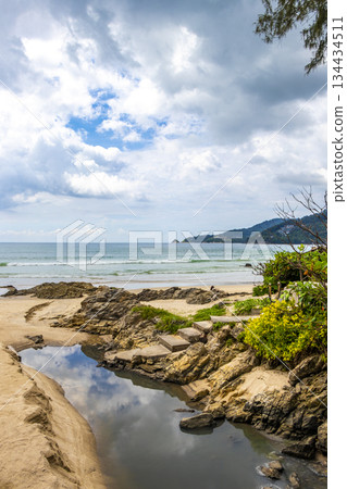 Rocky beach with rocks turquoise water palm trees Patong Thailand. Rocky beach with rocks turquoise water palm trees Patong Thailand. 134434511