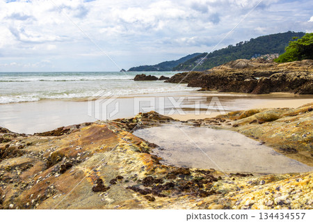 Rocky beach with rocks waves turquoise water in Patong Thailand. Rocky beach with rocks waves turquoise water in Patong Thailand. 134434557