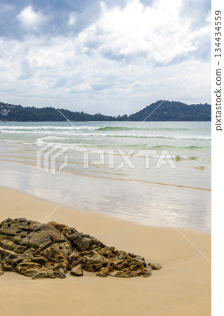 Rocky beach with rocks waves turquoise water in Patong Thailand. Rocky beach with rocks waves turquoise water in Patong Thailand. 134434559