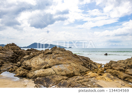 Rocky beach with rocks waves turquoise water in Patong Thailand. Rocky beach with rocks waves turquoise water in Patong Thailand. 134434569