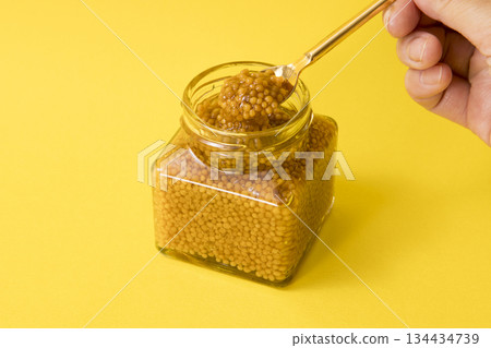 Scoop out the whole grain mustard with a spoon 134434739