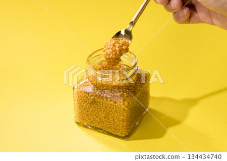 Scoop out the whole grain mustard with a spoon 134434740