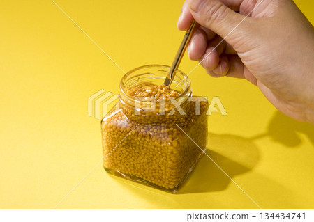 Scoop out the whole grain mustard with a spoon Scoop out the whole grain mustard with a spoon 134434741