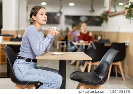 Young woman drinking coffee in cafe 134435176