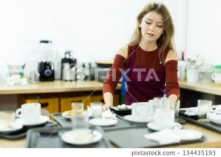 Waitress taking away dirty dish in cafeteria Waitress taking away dirty dish in cafeteria 134435193
