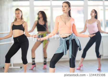 Woman performing high heels choreography during group class 134435306
