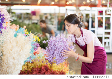 Portrait of female flower market seller with bouquets ruscus italie of flowers Portrait of female flower market seller with bouquets ruscus italie of flowers 134435315