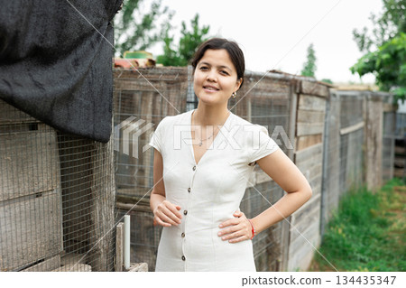 Portrait of young housewife of village house against backdrop of her estate 134435347