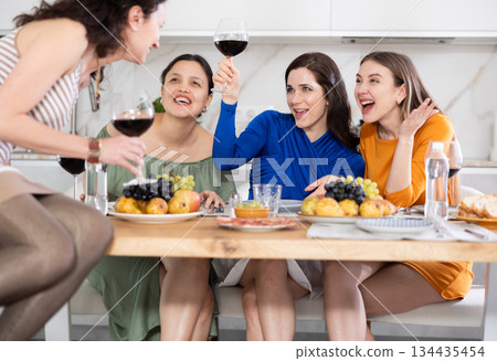 Happy women congregated around a festive table; participating in animated discussions and enjoying the delights of wine 134435454