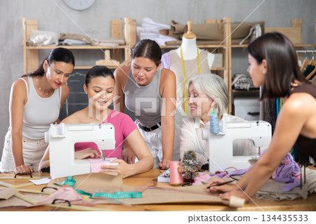 Middle-aged Asian woman showing how to sew Middle-aged Asian woman showing how to sew 134435533