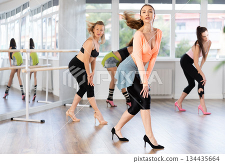 Female dancer performing hair whips in high heels dance class 134435664