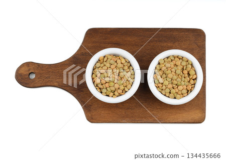Green lentils in wooden bowl on isolated white background. Top view, copy space. Flat lay. 134435666