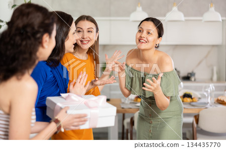 Three women have arrived for birthday celebration and presenting gift to birthday woman Three women have arrived for birthday celebration and presenting gift to birthday woman 134435770