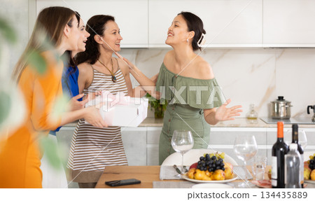 Asian woman greeting friends bringing gift for home party 134435889