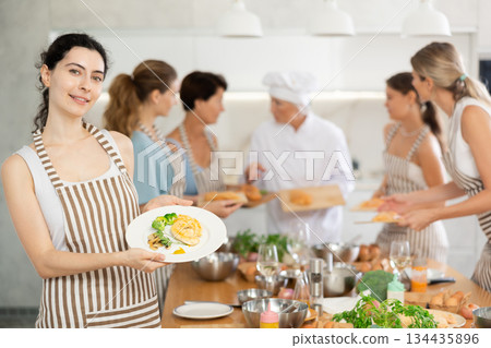 Young woman posing with cooked chicken at master class Young woman posing with cooked chicken at master class 134435896
