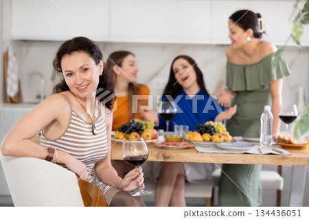 Adult woman drinking wine with her friends Adult woman drinking wine with her friends 134436051
