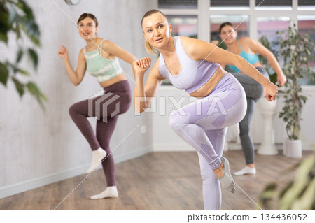 Positive women engaged in active dancing 134436052