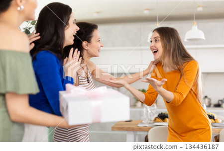Delighted young woman receiving besties at birthday bash 134436187