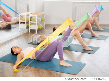 Group of people with working out with rubber bands in gym Group of people with working out with rubber bands in gym 134436282