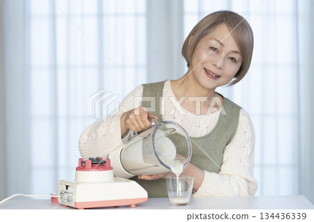 老婦人在廚房用果汁機製作健康果汁 134436339
