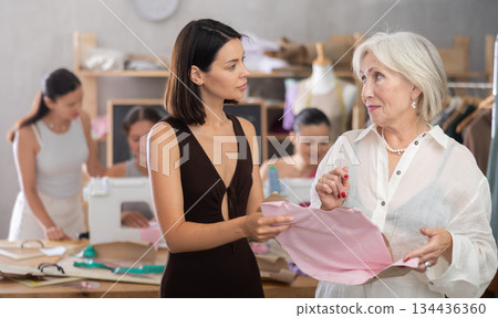 Young girl showing detail on paper to unsatisfied teacher 134436360