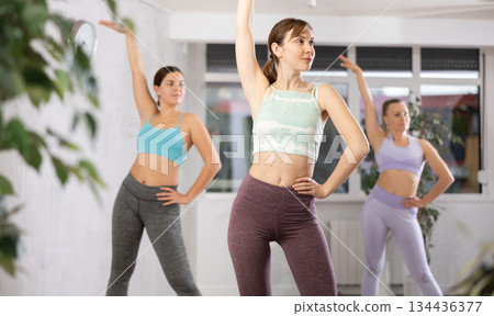 Happy women doing aerobic dances together in dance studio Happy women doing aerobic dances together in dance studio 134436377