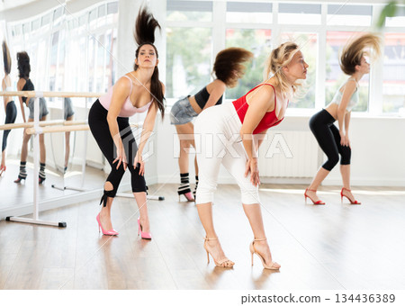 During lesson, woman learn to move and perform dance in heels with women companions 134436389