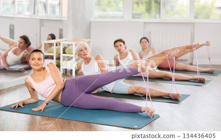 Young woman exercising with pilates loop Young woman exercising with pilates loop 134436405