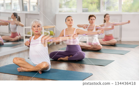 Elderly woman exercising with pilates loop Elderly woman exercising with pilates loop 134436418