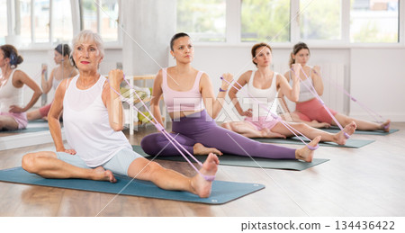 Elderly woman exercising with pilates loop 134436422
