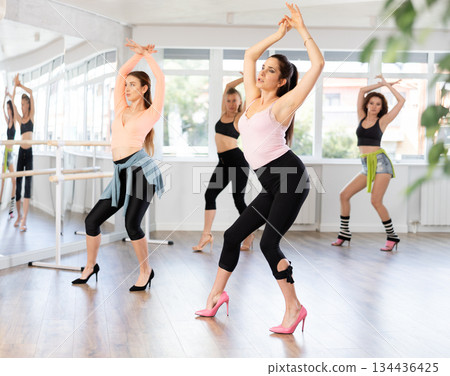 Woman performing modern high heels choreography at dance class 134436425