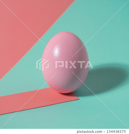 Creative still life with pink egg on teal and coral background showing simple shapes and colors 134436575