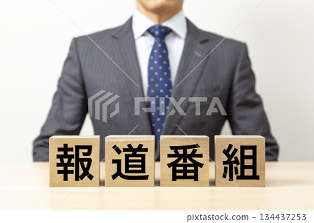 A block with the word "news program" written on it and a businessman A block with the word "news program" written on it and a businessman 134437253