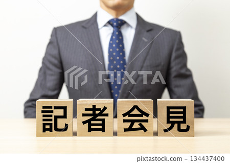 一塊寫著「記者會」字樣的磚塊和一個商人 一塊寫著「記者會」字樣的磚塊和一個商人 134437400