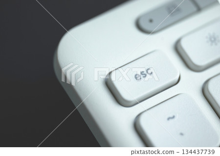 Fingers hover over the escape key on a keyboard 134437739