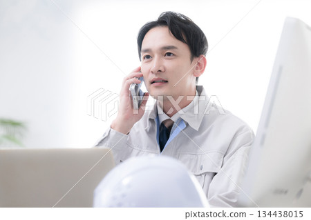 A worker answering the phone at the site office. Close-up of the image of work orders and subcontracting. 134438015
