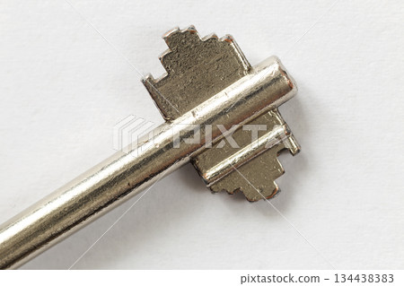 Close-up detail of old well-used steel key isolated on white copy space background. Safety and security concept. Close-up detail of old well-used steel key isolated on white copy space background. Safety and security concept. 134438383