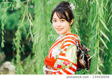 一個穿著和服（袖）站在柳樹下的女人 134438936