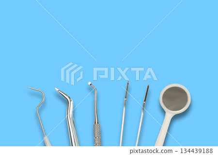 Dental instruments are displayed on a simple blue background Dental instruments are displayed on a simple blue background 134439188