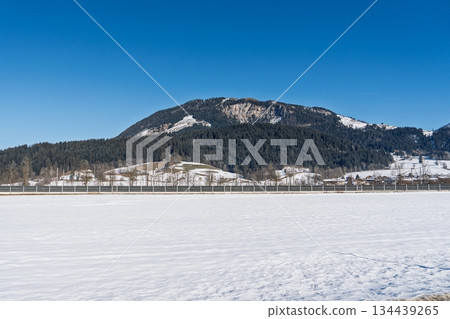 Serene Winter Landscape in Kaprun, Austria Alps A Mountain Backdrop Under Clear Blue Skies 134439265
