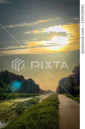 The tranquil serene sunset beautifully illuminates the calm waterway scenic path ahead The tranquil serene sunset beautifully illuminates the calm waterway scenic path ahead 134439462